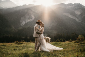 Boho Brautpaar in den Alpen bei Sonnenuntergang